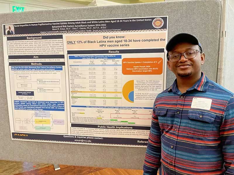 nixon arauz standing in front of a research poster titled 'racial disparities in human papillomavirus vaccine uptake among adult black and white latinx men aged 18-34 years in the united states: behavioral risk factors surveillance system 2014-2022