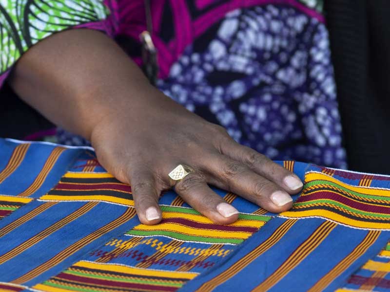 a person's hand atop a colorful fabric