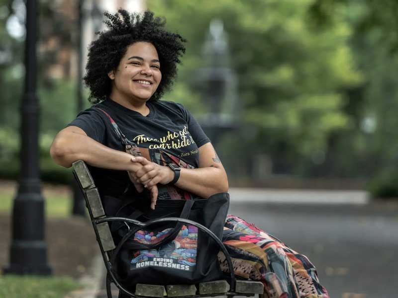 jae lange smiling while sitting on a bench in monroe park at v.c.u.