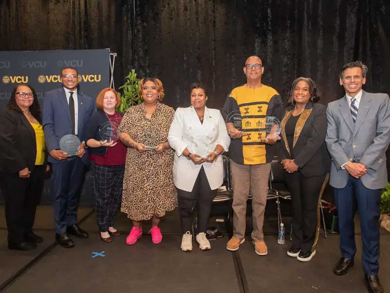 eight pacme award winners standing on a stage