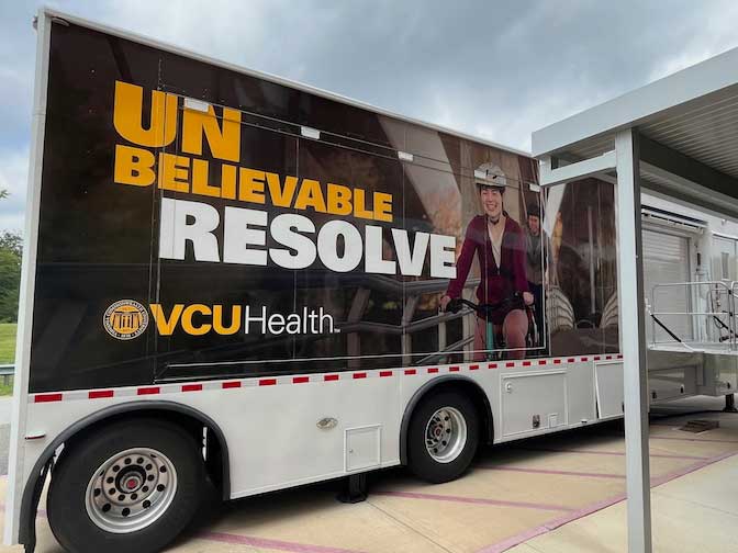 a v.c.u. mobile health vehicle with a banner on the side that reads 'unbelievable resolve'